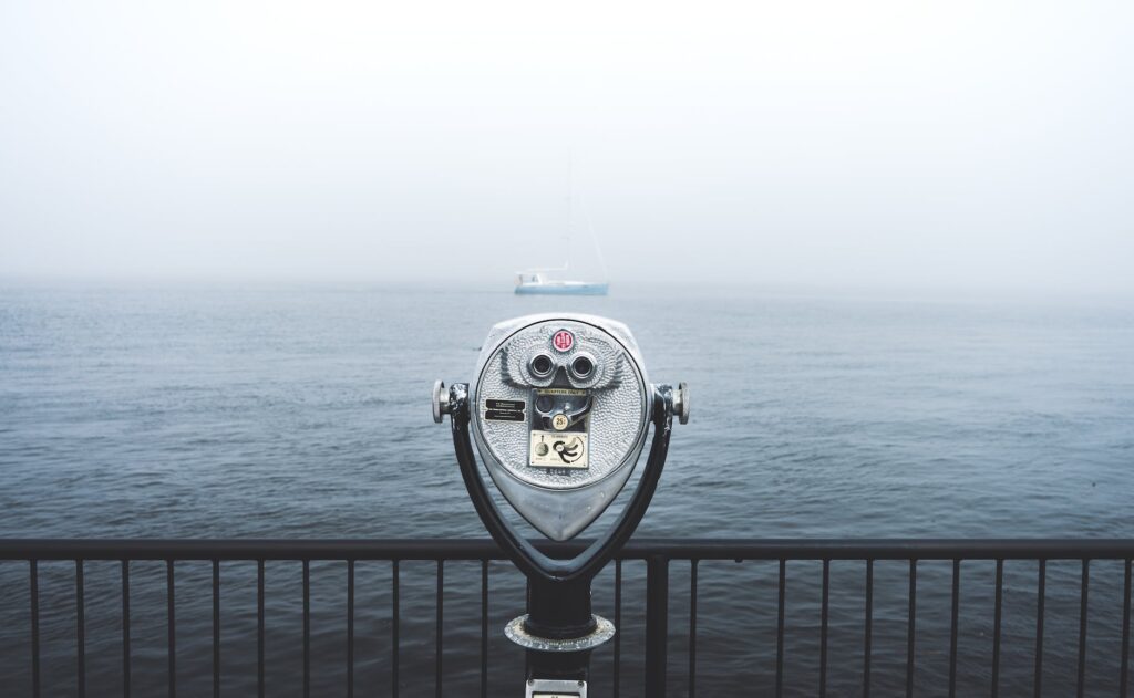 telescope in front of body of water